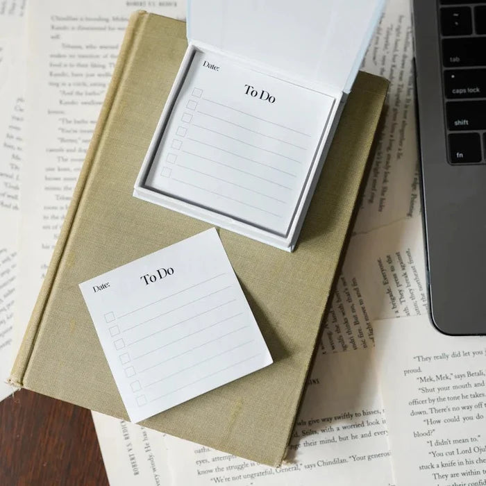 To Do Sticky Notes pad from LitJoy Winter Romantasy TBR Box — white notepad with checkboxes and date field displayed open on a book beside laptop keyboard