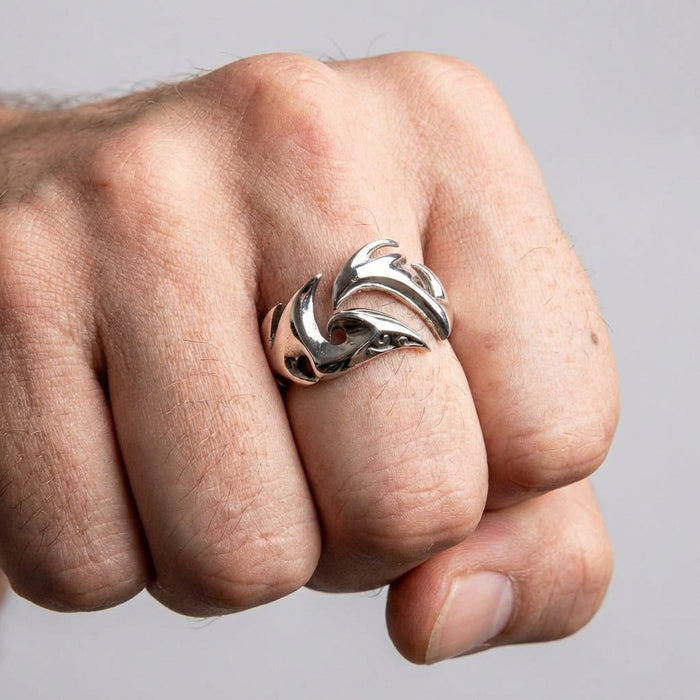 A man's fist wearing the wide silver tribal band, showcasing its prominent statement style.