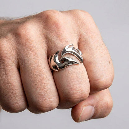 A man's fist wearing the wide silver tribal band, showcasing its prominent statement style.