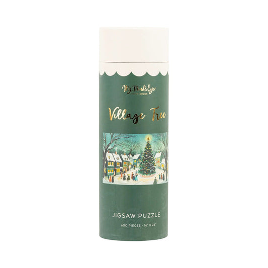 The Village Tree | 600 Piece Jigsaw Puzzle by My Mind's Eye comes in a cylindrical container and features a festive snowy village scene with a decorated tree.