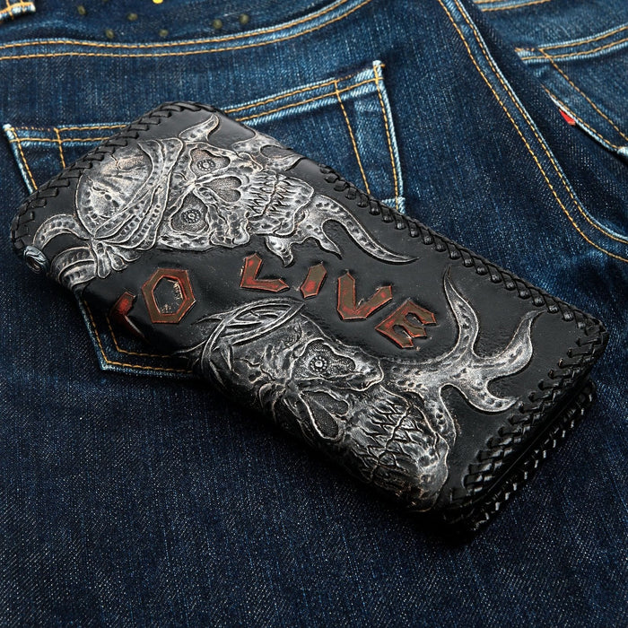 Embossed horned skulls in a silver finish with TO LIVE picked out in red, whipstitched round the edge.