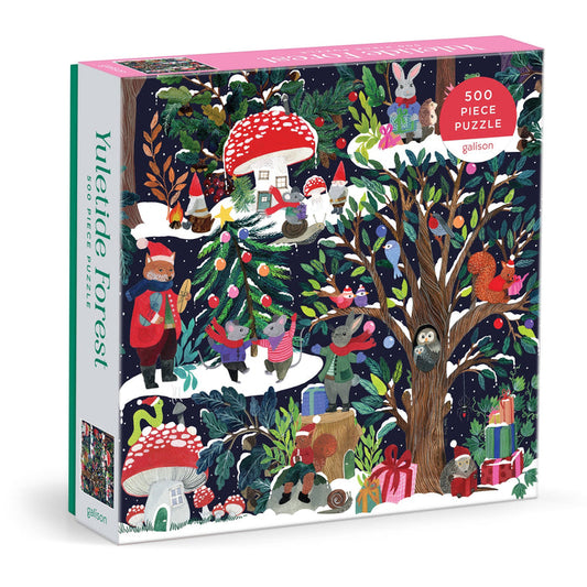 The Galison Yuletide Forest 500 Piece Jigsaw Puzzle features illustrated animals, gnomes, a tree, gifts, and mushrooms in a festive nighttime woodland holiday scene.